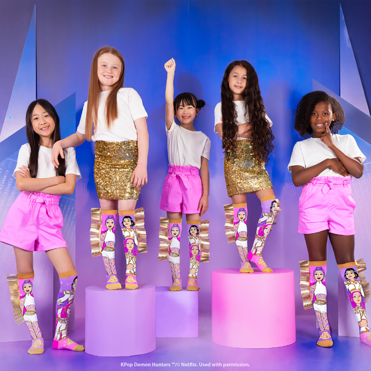 Crianças a usar meias Huntrix™ coloridas com personagens K-Pop Demon Hunters e franjas douradas